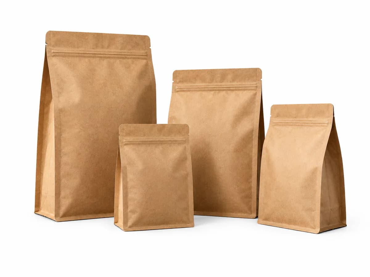 Four natural kraft paper stand-up pouches in different sizes